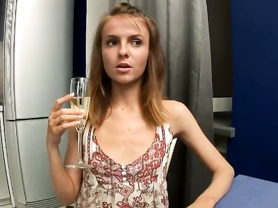 Худая девушка выпивает бокал вина на кухне и мастурбирует пилотку